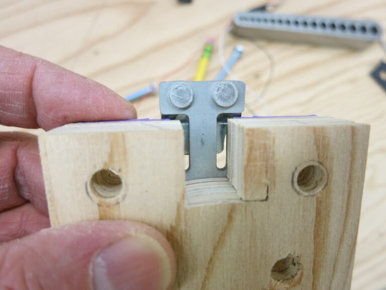 Holding a Load Sensor over a support block that has mounting holes in it