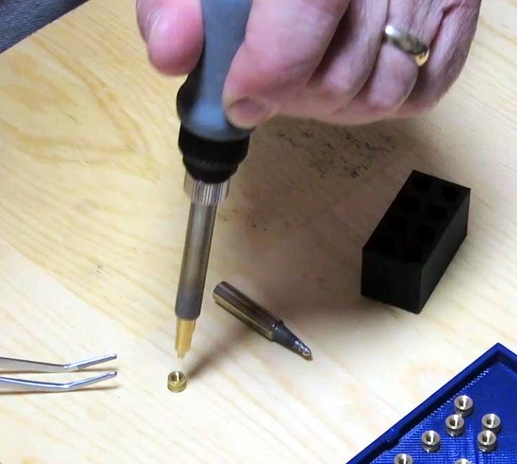 Pushing the soldering iron into the heat-set insert