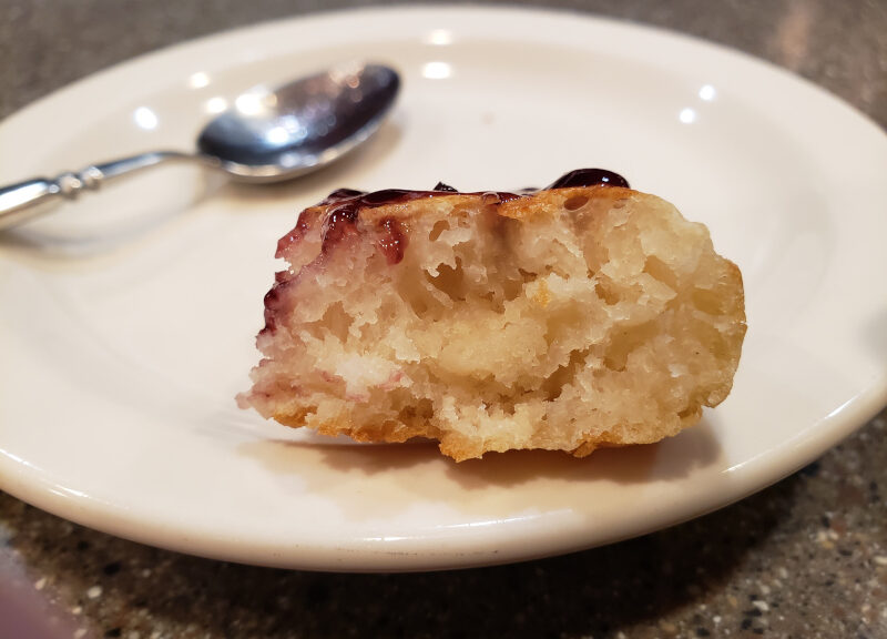 The interior of a lovely crumpet spread with jam
