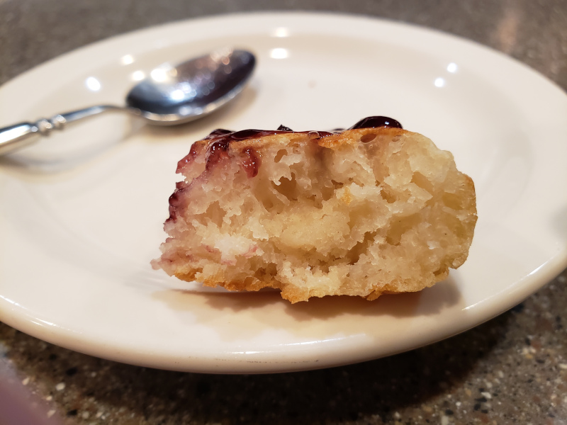 The interior of a lovely crumpet spread with jam